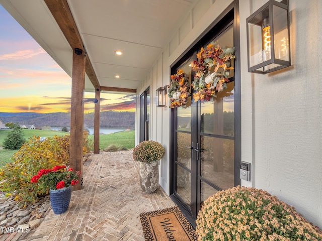 patio terrace at dusk featuring a water view