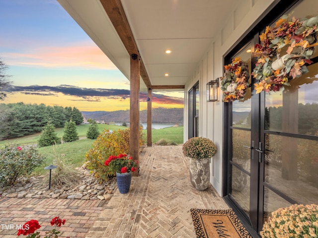 patio terrace at dusk featuring a mountain view