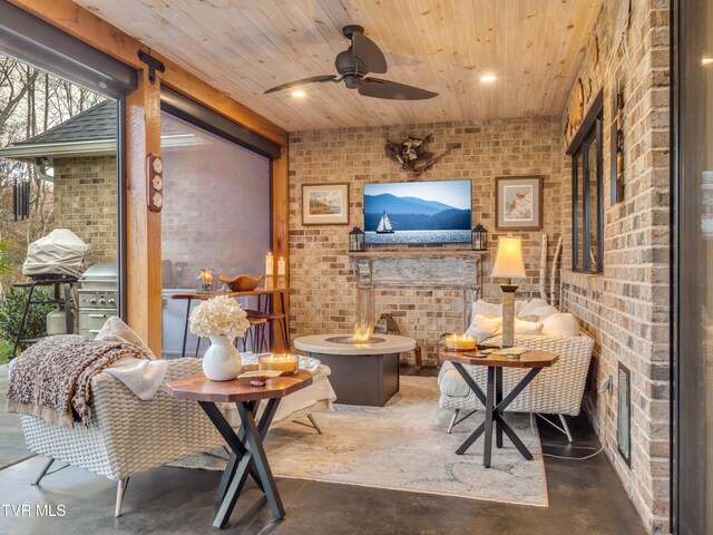 living area featuring concrete flooring, wood ceiling, ceiling fan, and brick wall