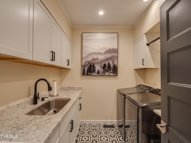 washroom featuring cabinets, sink, ornamental molding, light tile patterned floors, and washing machine and clothes dryer