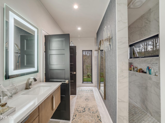 bathroom with tile walls, vanity, and tiled shower