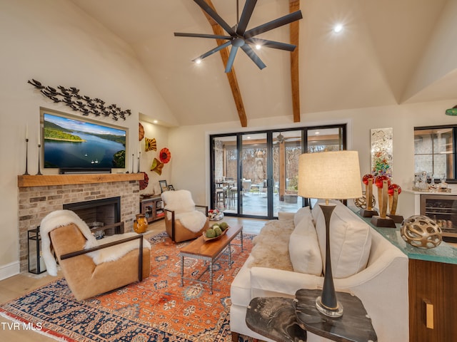 living room featuring high vaulted ceiling, a brick fireplace, ceiling fan, and beam ceiling