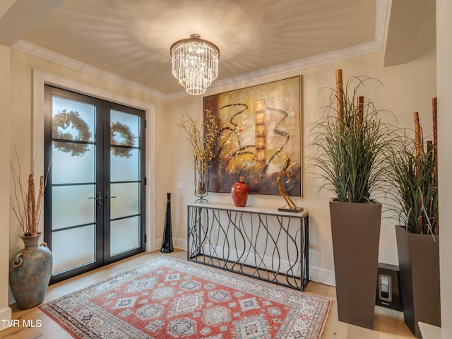 entrance foyer with french doors, light hardwood / wood-style floors, and crown molding