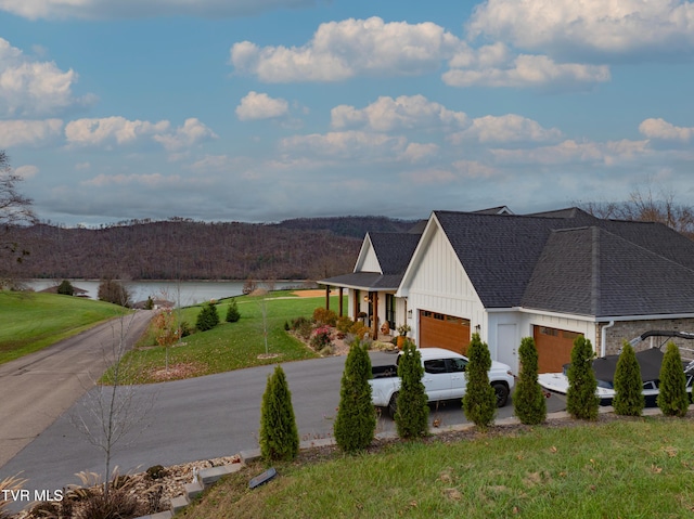 175 Deer Ridge Ct, Butler, TN 37640 - view of front of house featuring board and batten siding, a garage, a front yard, concrete driveway, and a water view