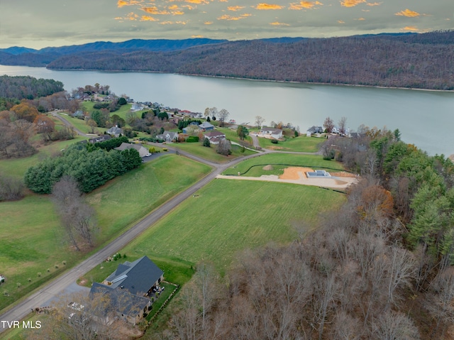 aerial view at dusk featuring a water and mountain view