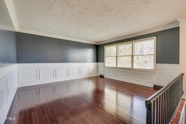 spare room featuring a textured ceiling, crown molding, and dark hardwood / wood-style floors