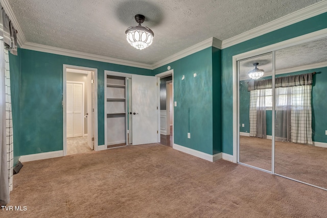 unfurnished bedroom featuring carpet, a textured ceiling, a closet, and ornamental molding