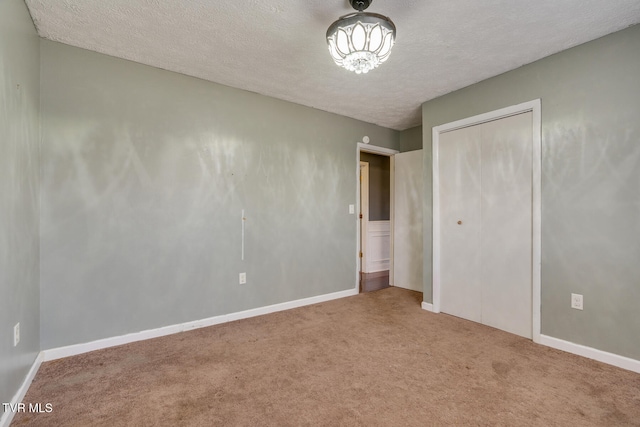 unfurnished bedroom featuring carpet flooring, a textured ceiling, and a closet