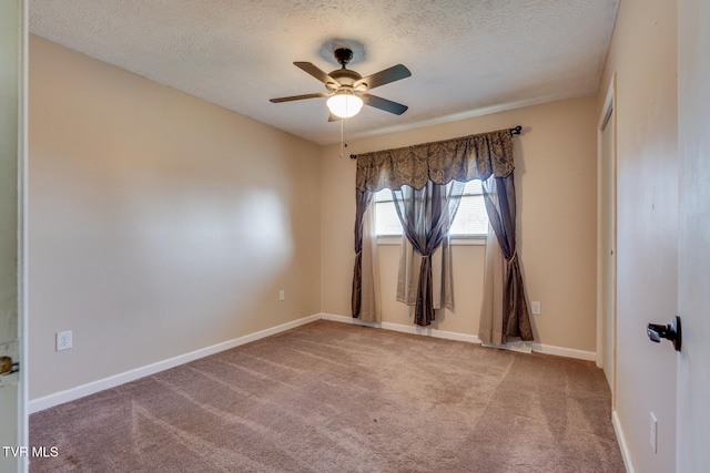 carpeted spare room with a textured ceiling and ceiling fan