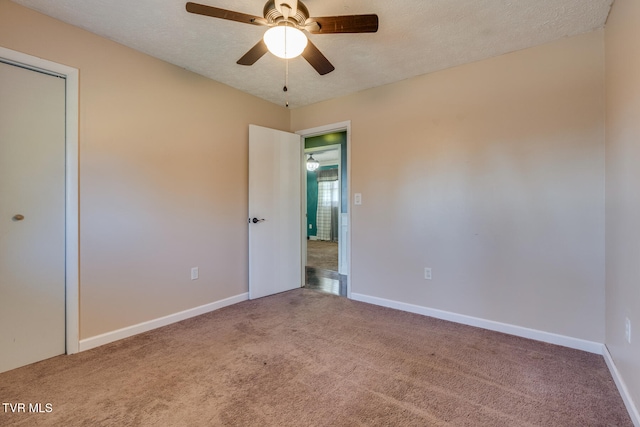 spare room featuring ceiling fan, carpet, and a textured ceiling