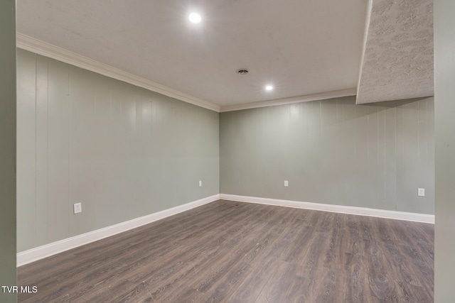 empty room with ornamental molding, dark wood-type flooring, and wood walls