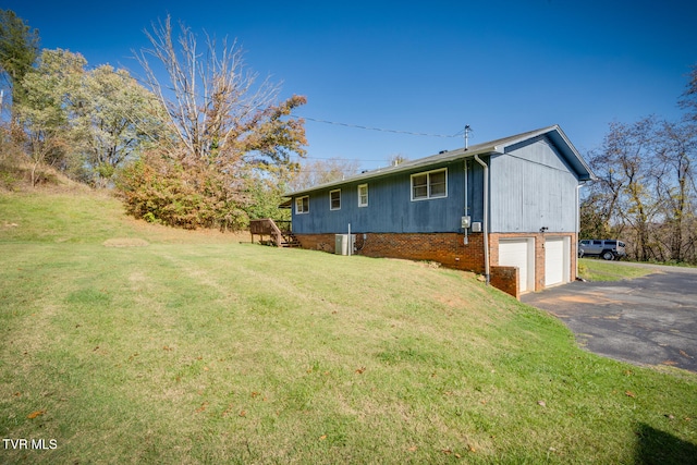 view of side of home featuring a lawn and a garage