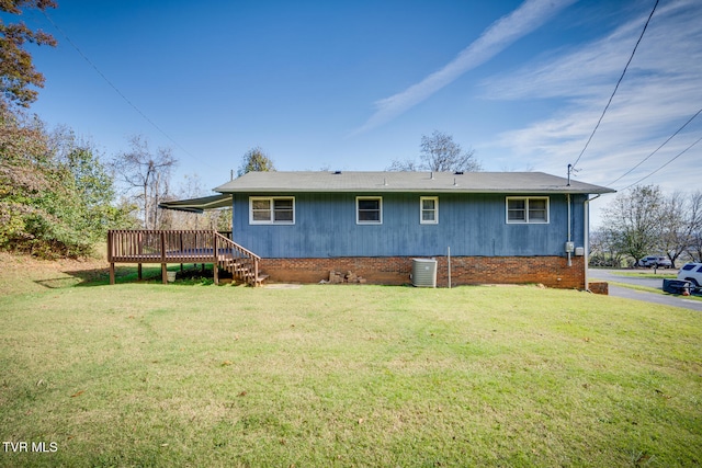 rear view of property featuring a deck and a yard