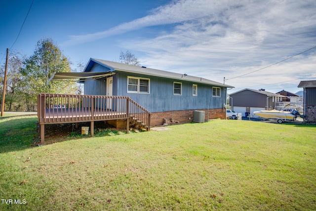 rear view of property with a yard, a deck, and central AC unit