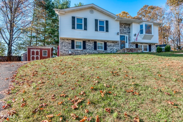 raised ranch with a front lawn and a storage unit