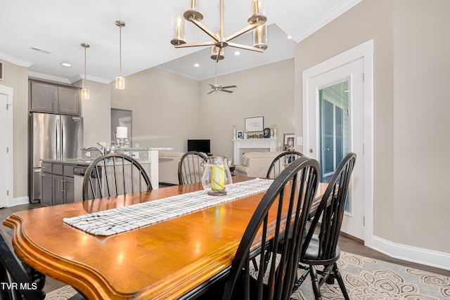 dining area with ceiling fan with notable chandelier, hardwood / wood-style flooring, and crown molding