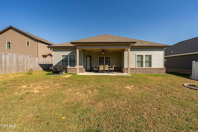 rear view of property featuring ceiling fan, a yard, and a patio area