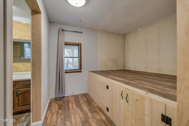 hallway featuring wood finished floors and visible vents