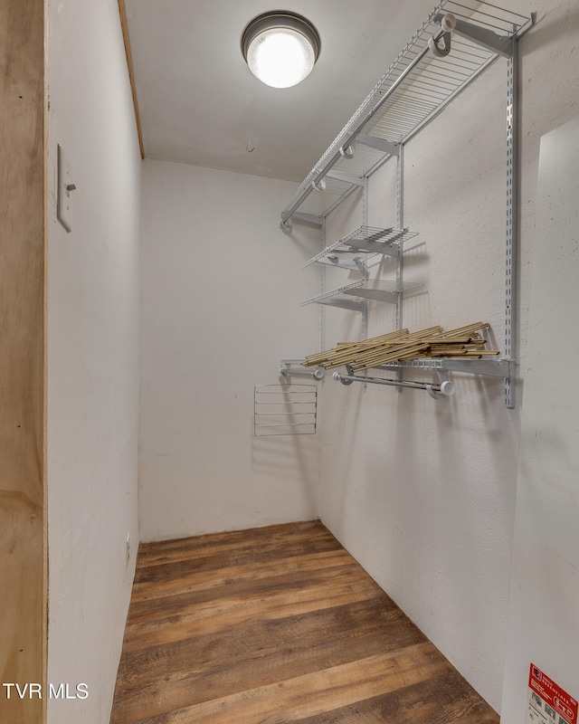 walk in closet with wood finished floors