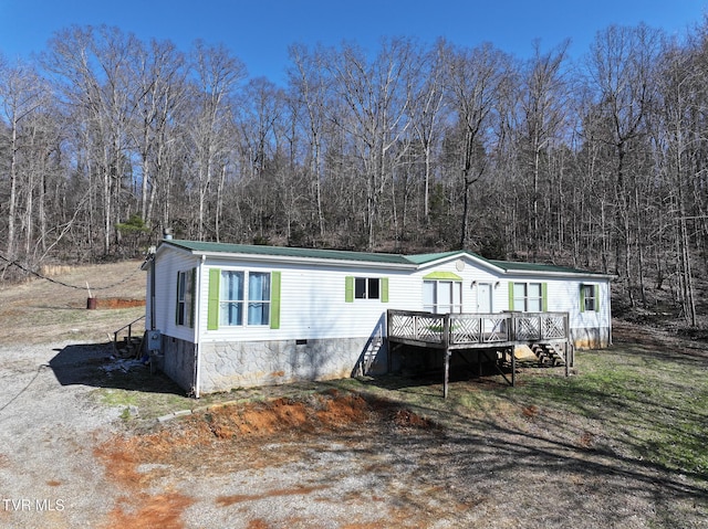 view of front facade featuring a view of trees, stairway, metal roof, crawl space, and a deck