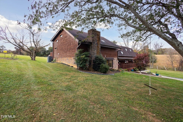 view of home's exterior with central air condition unit and a yard