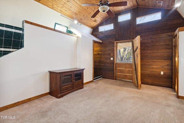 unfurnished living room featuring light carpet, ceiling fan, high vaulted ceiling, wood ceiling, and wooden walls