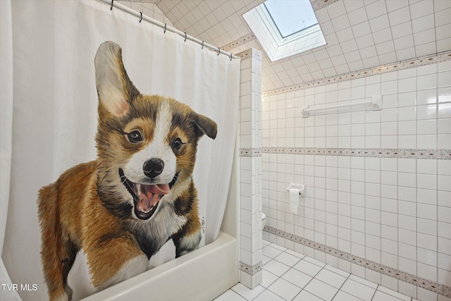 bathroom with shower / bath combo with shower curtain, tile patterned flooring, toilet, and a skylight