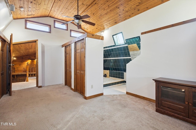 hall featuring high vaulted ceiling, wood walls, light carpet, and wood ceiling