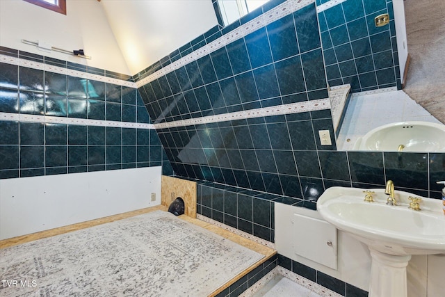 bathroom featuring tile walls and lofted ceiling