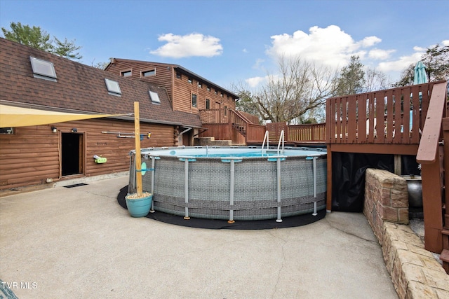 view of swimming pool featuring a patio area and a wooden deck