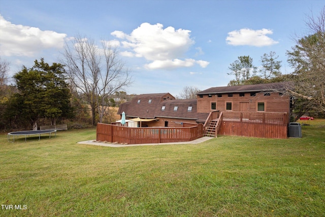 view of yard with central air condition unit, a trampoline, and a deck