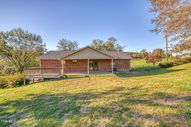 view of front of home with a deck, a front yard, and cooling unit