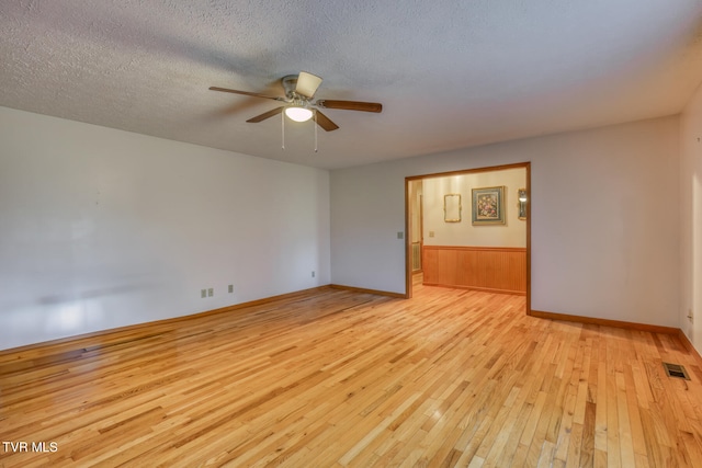 empty room featuring ceiling fan, a textured ceiling, and light hardwood / wood-style floors