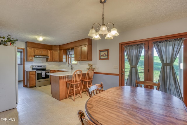 dining space with a chandelier, a textured ceiling, and sink