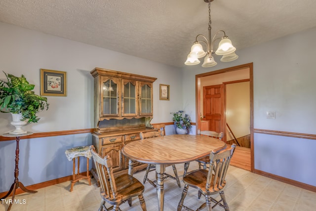 dining area featuring a chandelier and a textured ceiling