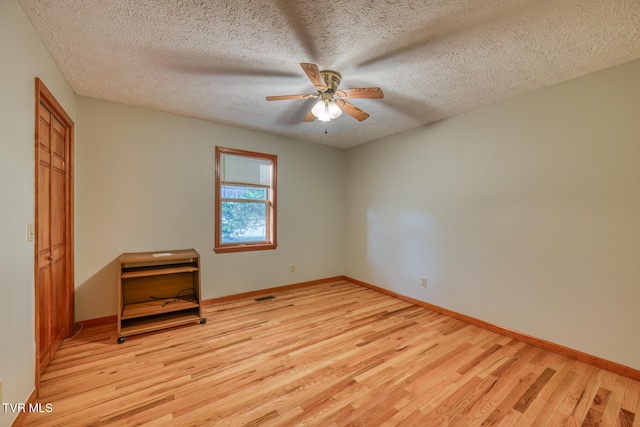 unfurnished bedroom with light wood-type flooring, a textured ceiling, and ceiling fan