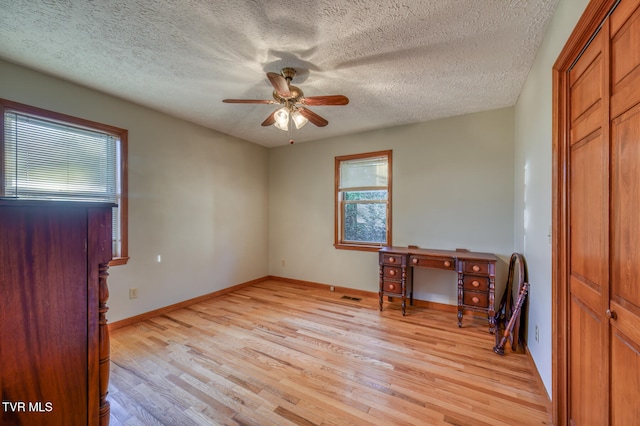 entryway featuring light hardwood / wood-style floors, a textured ceiling, and ceiling fan