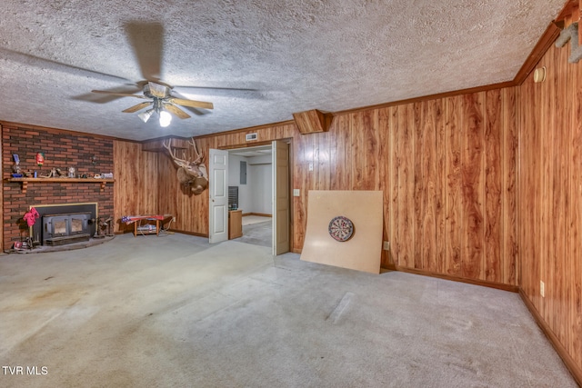 unfurnished living room featuring wood walls, a wood stove, and a textured ceiling