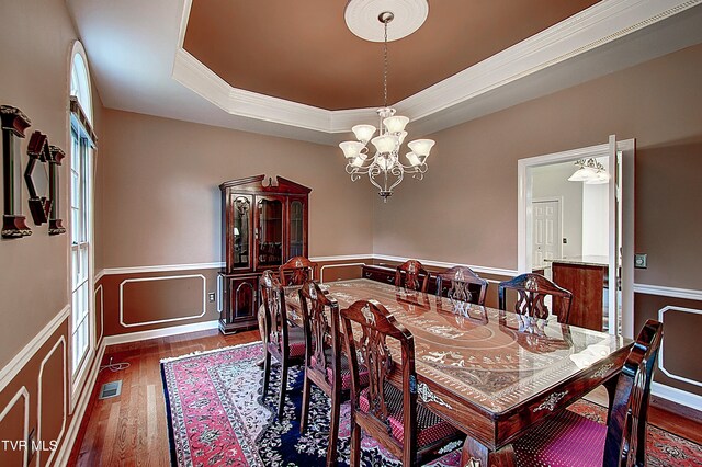 dining area featuring a raised ceiling, plenty of natural light, a notable chandelier, and dark hardwood / wood-style floors