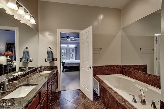 bathroom featuring tiled bath, a textured ceiling, tile patterned floors, ceiling fan, and vanity