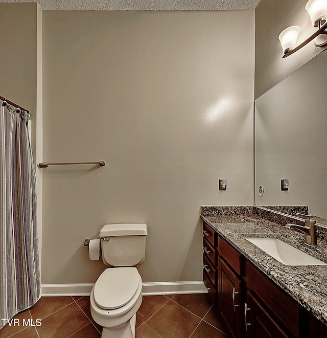 bathroom with toilet, vanity, and tile patterned floors