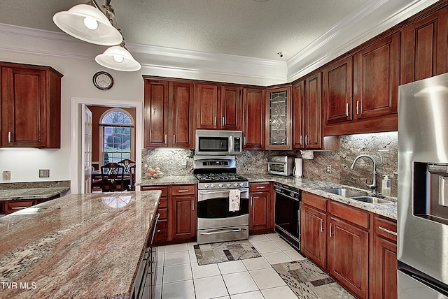 kitchen with appliances with stainless steel finishes, light tile patterned floors, light stone counters, sink, and decorative light fixtures