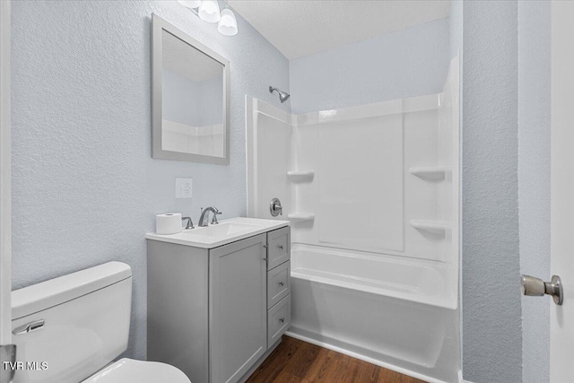 full bathroom with hardwood / wood-style flooring, a textured ceiling, vanity, shower / bathing tub combination, and toilet