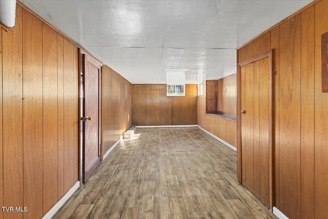 corridor with wooden walls and hardwood / wood-style flooring