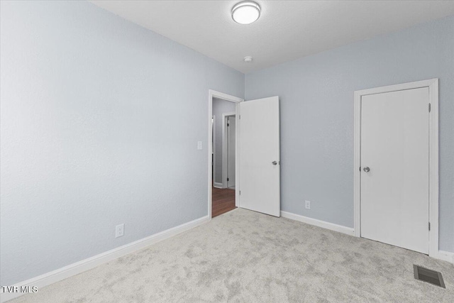 unfurnished bedroom with light colored carpet