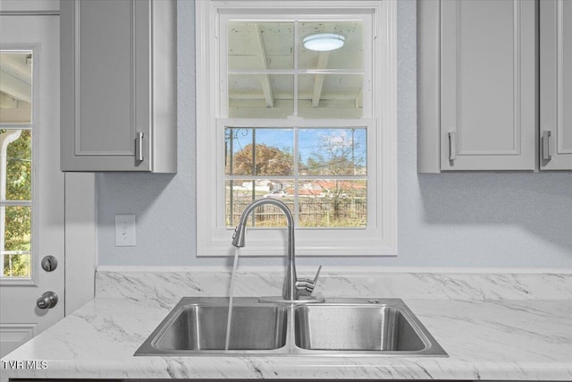 kitchen featuring light stone countertops and sink