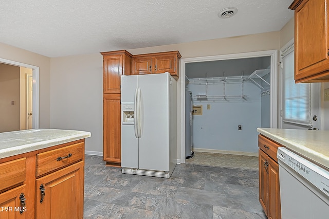 kitchen featuring water heater, white appliances, and a textured ceiling