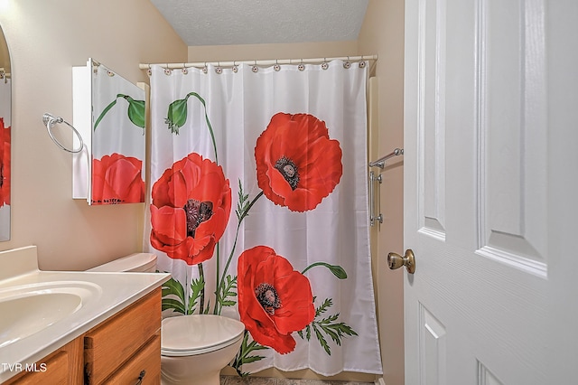 bathroom featuring toilet, vanity, a textured ceiling, and walk in shower