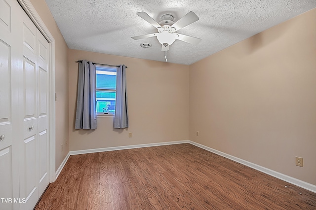 spare room featuring hardwood / wood-style flooring, ceiling fan, and a textured ceiling