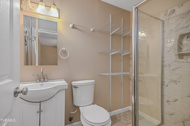 bathroom with an enclosed shower, vanity, a textured ceiling, and toilet